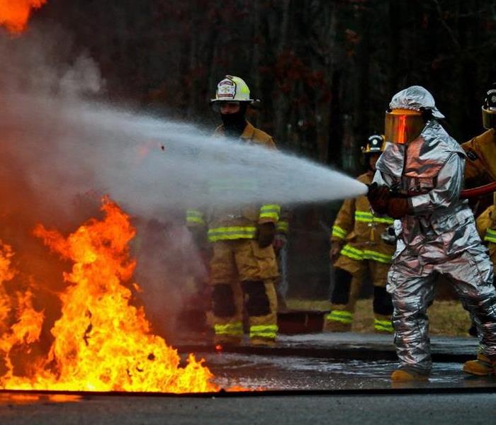 A fire hazard professional extinguishing a fire.